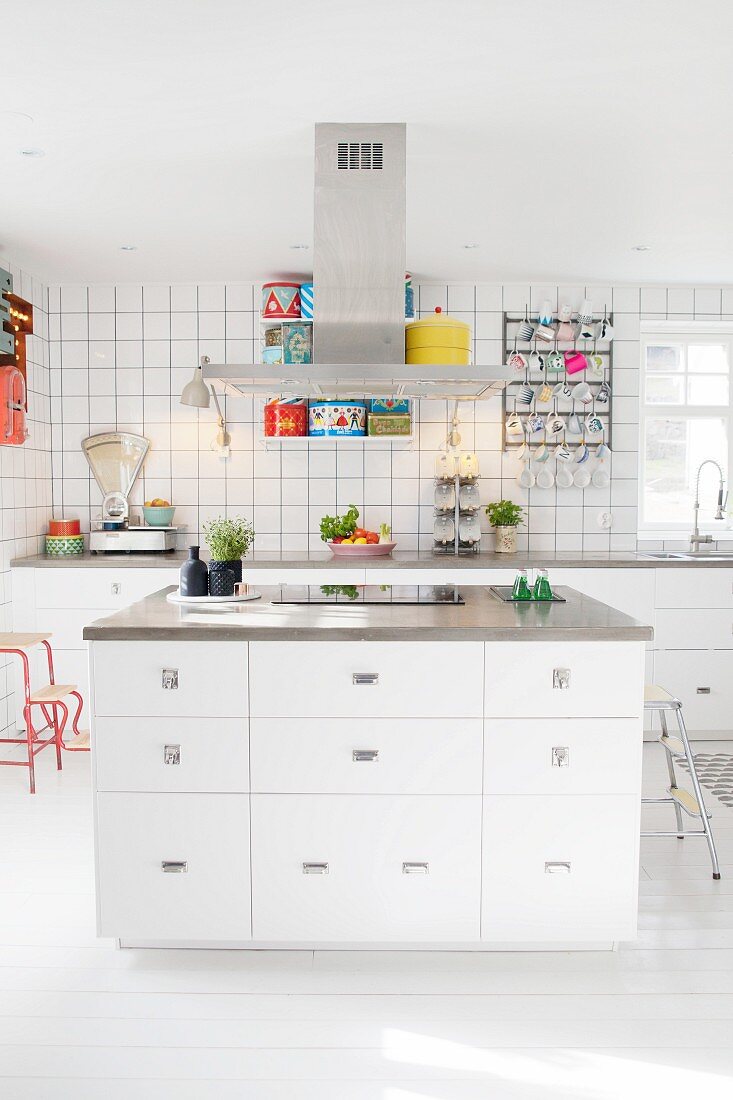 weiße Einbauküche mit Kücheninsel, Retro Küchenwaage und bunten Blechdosen