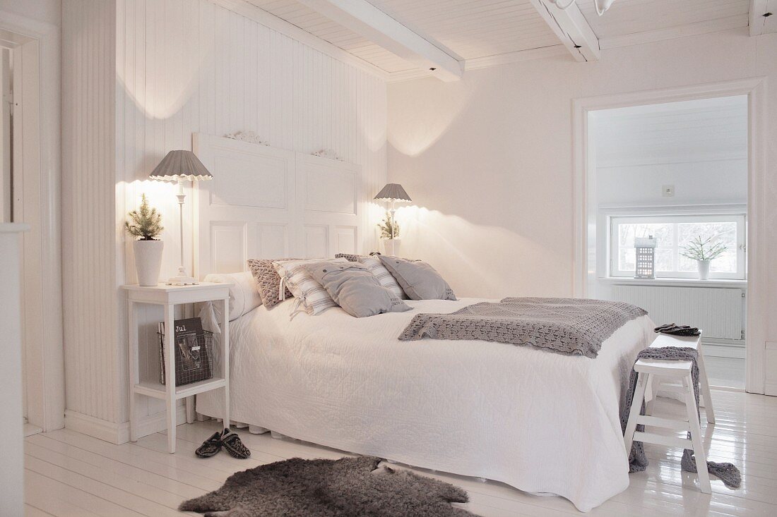 White and grey bedroom with wooden floor and ceiling