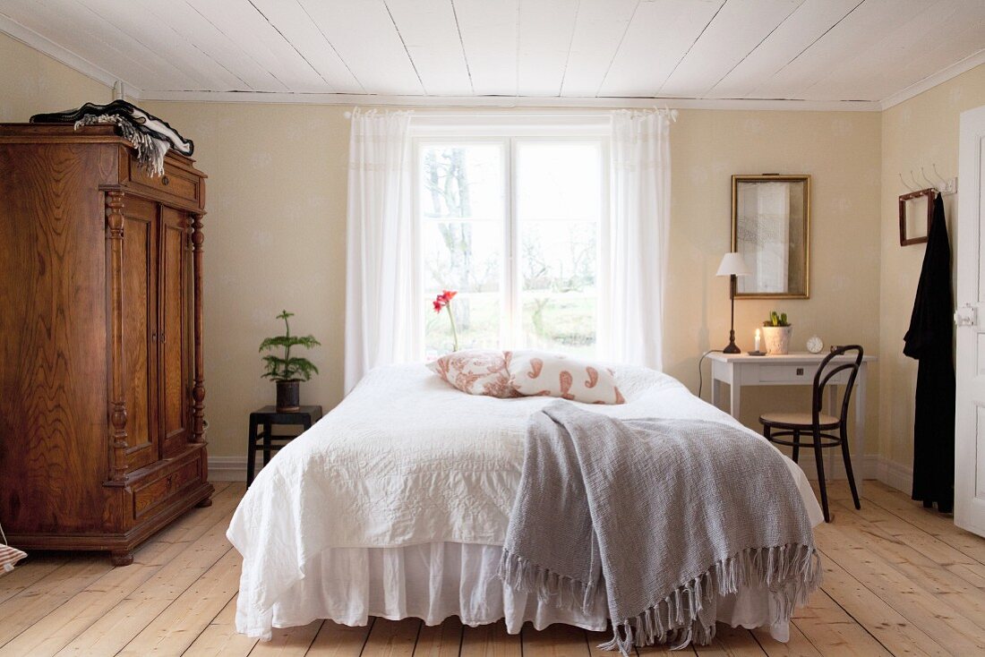 Country-house-style bedroom with low ceiling and wooden floor