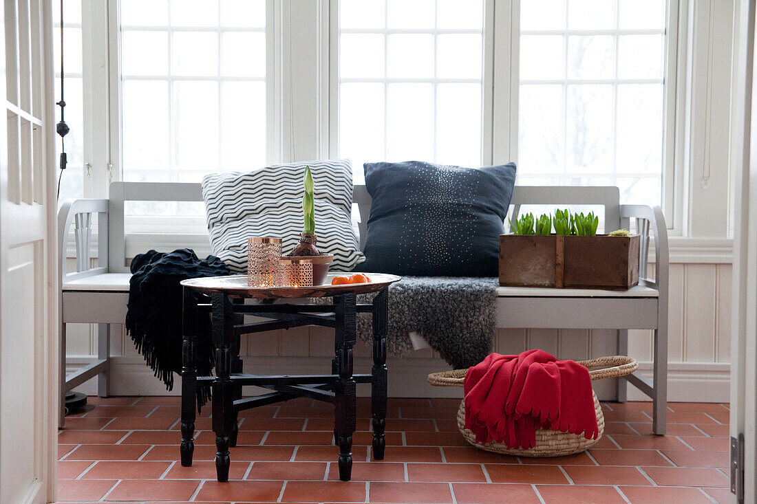 Oriental tray table in front of bench in conservatory