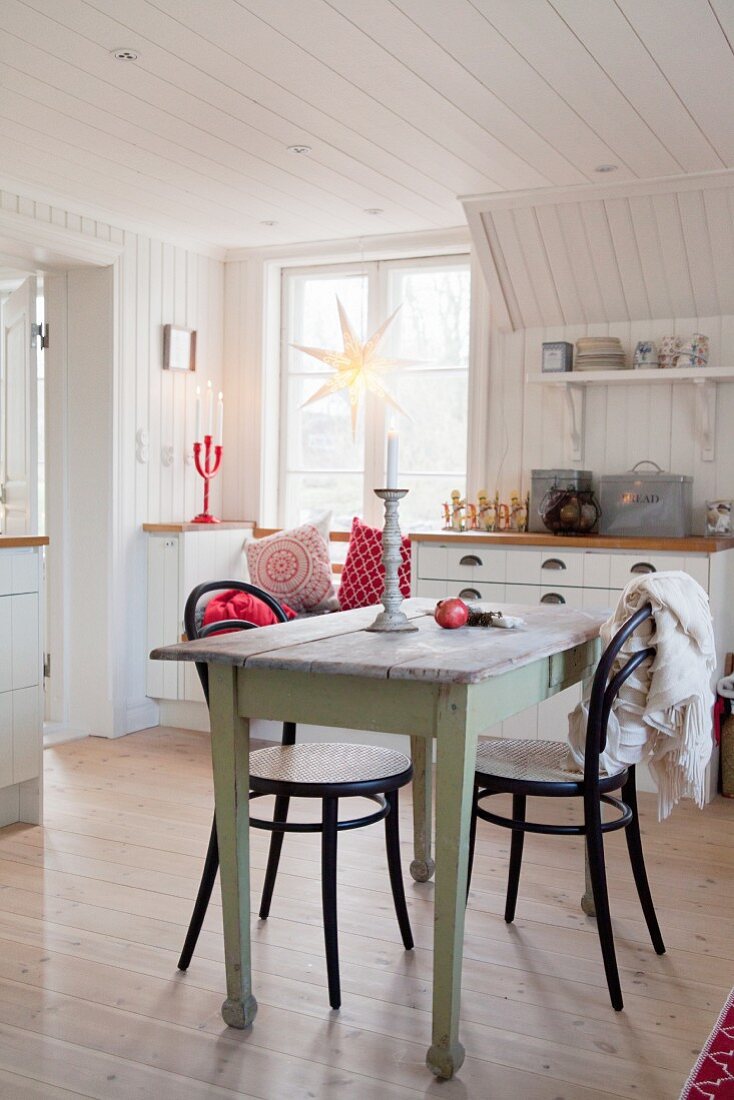 Alter Holztisch mit Kaffeehausstühlen in Wohnküche