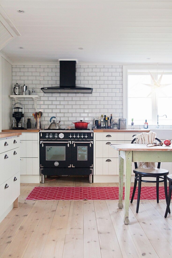 Dining area and vintage-style cooker in large country-house kitchen