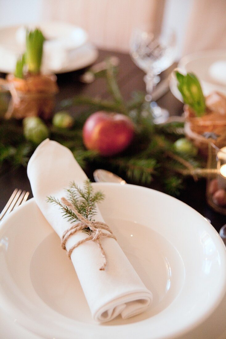 White place setting with festively decorated linen napkin