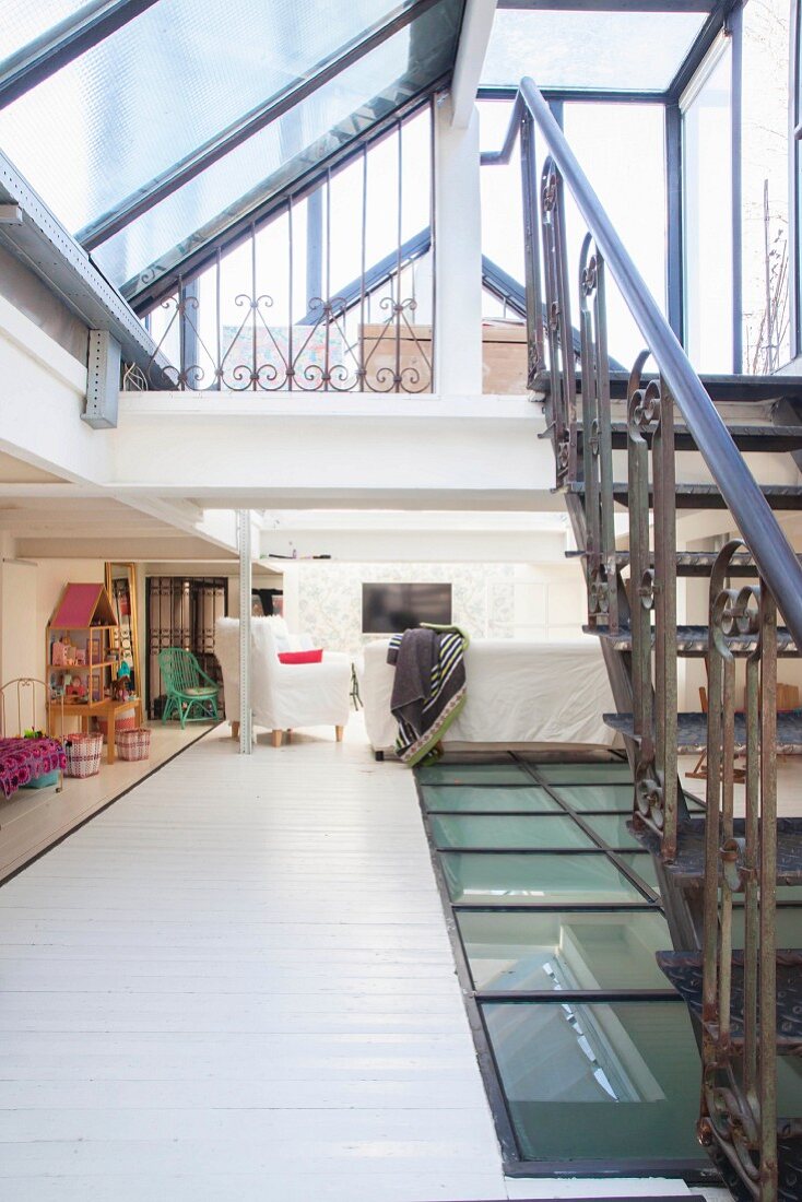 Galerieraum mit Spielzeug, Fernseher und Verglasung, Stahltreppe zu zweiten Galerie mit Glasdach