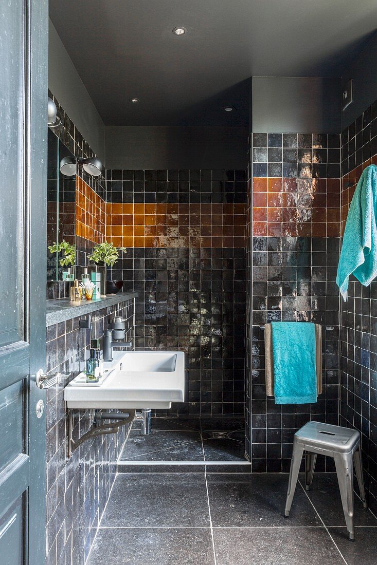 Black-tiled bathroom with shower area