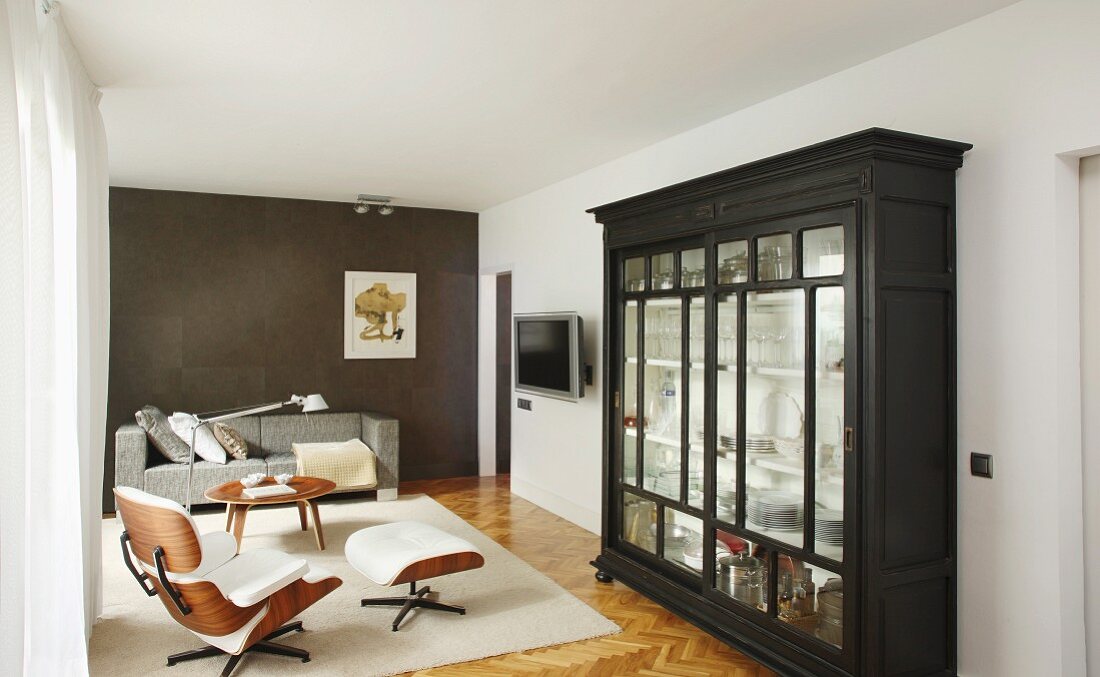 Vitrinenschrank, Lounge Chair, Coffeetable und Sofa in elegantem Wohnbereich