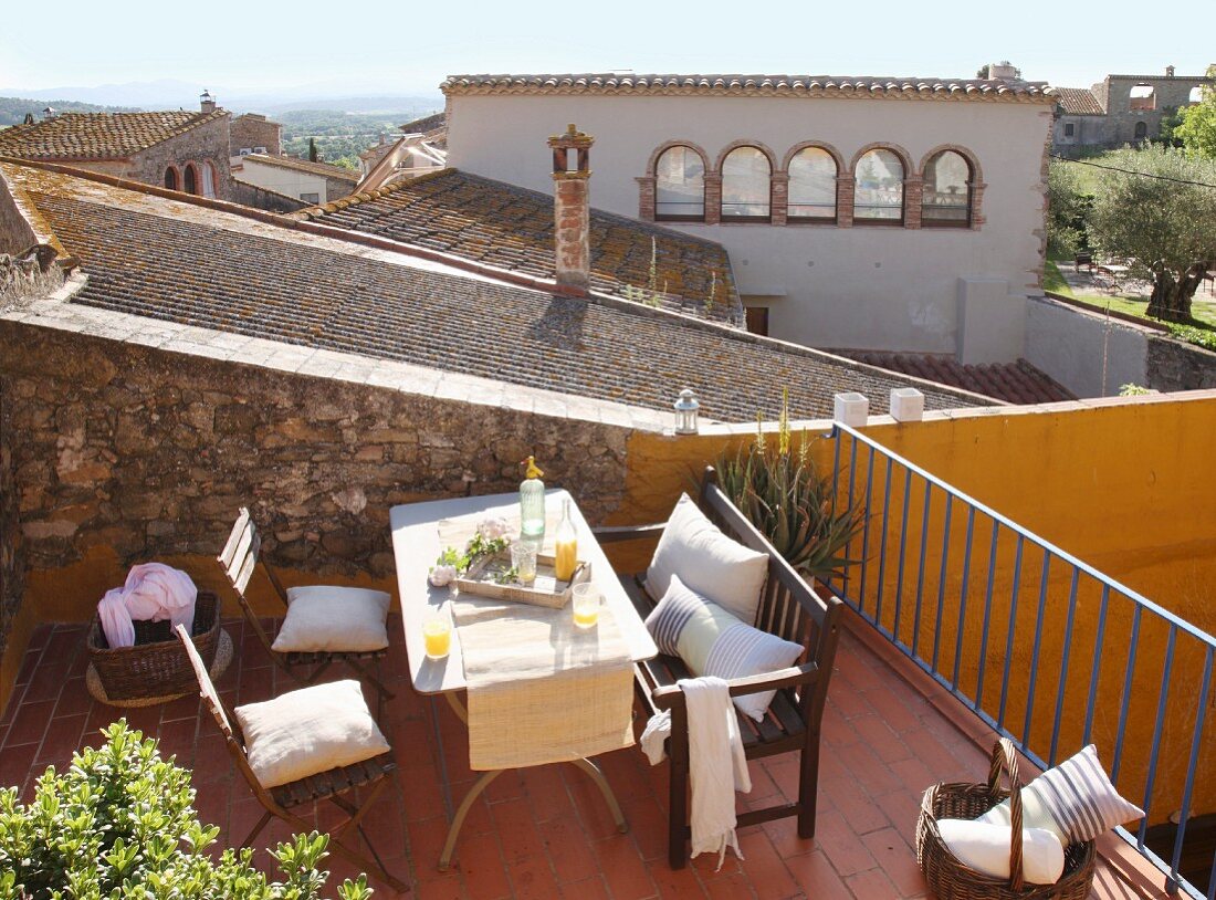 Sonniger Sitzplatz auf der Terrasse mit Blick über mediterrane Dächer