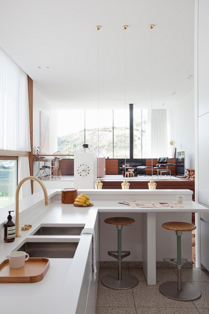 Designer kitchen with breakfast bar in open-plan interior