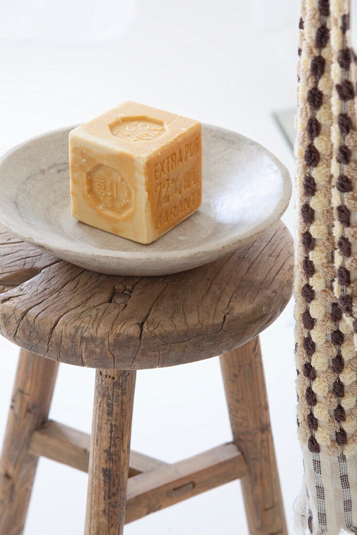 Soap in soap dish on rustic wooden stool