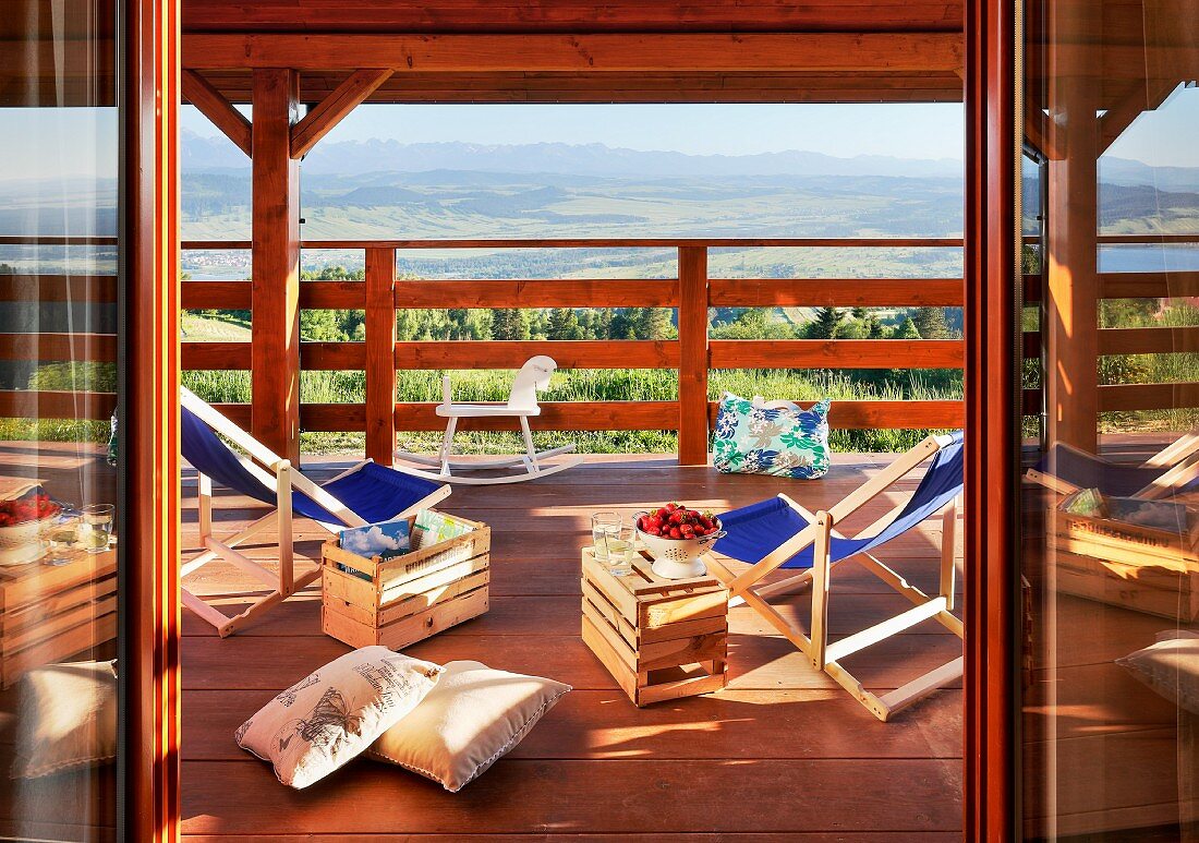 Liegestühle mit Holzkisten als Beistelltische auf dem Balkon