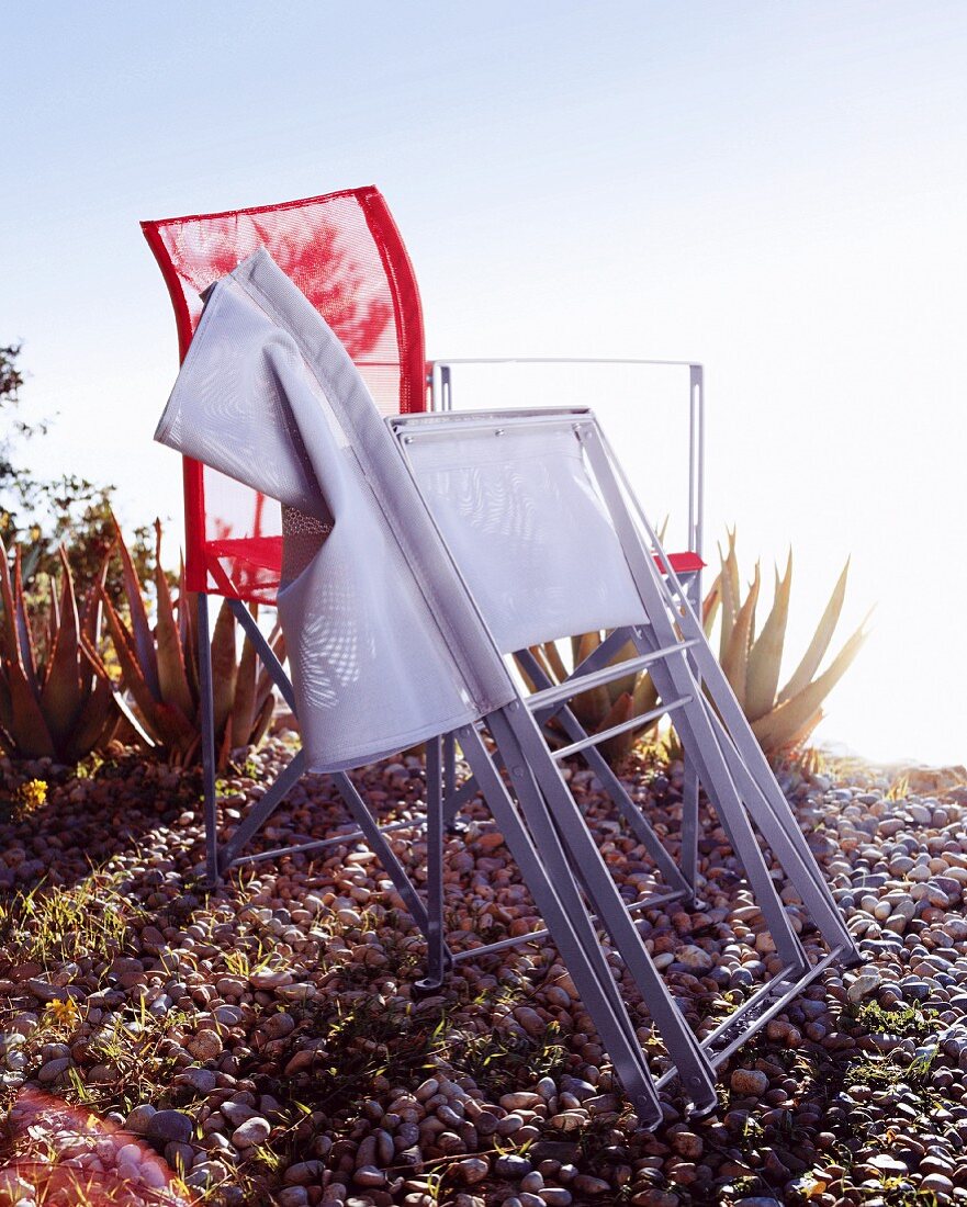 Two folding chairs with a view on gravel