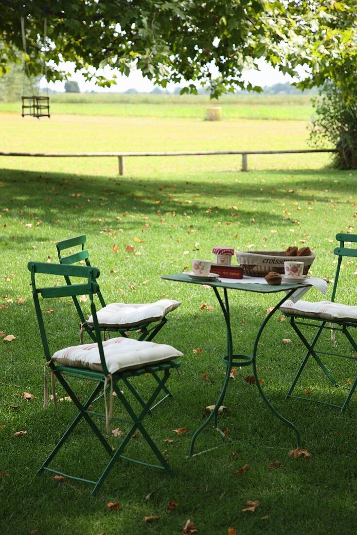 Schattiger Gartenplatz mit gedecktem Tisch auf Rasen