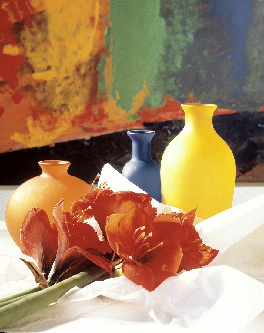 Drei farbenfrohe Vasen & Amaryllisblüten auf dem Tisch