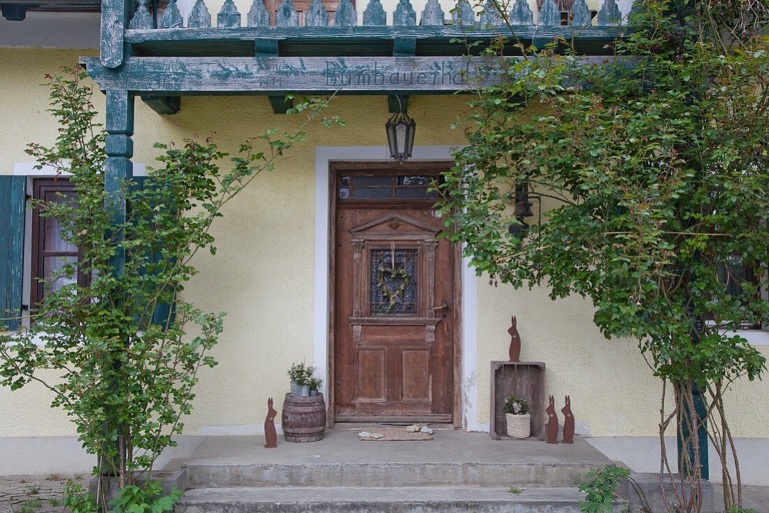 Dekorierter Hauseingang mit antiker Holztür und Osterhasen