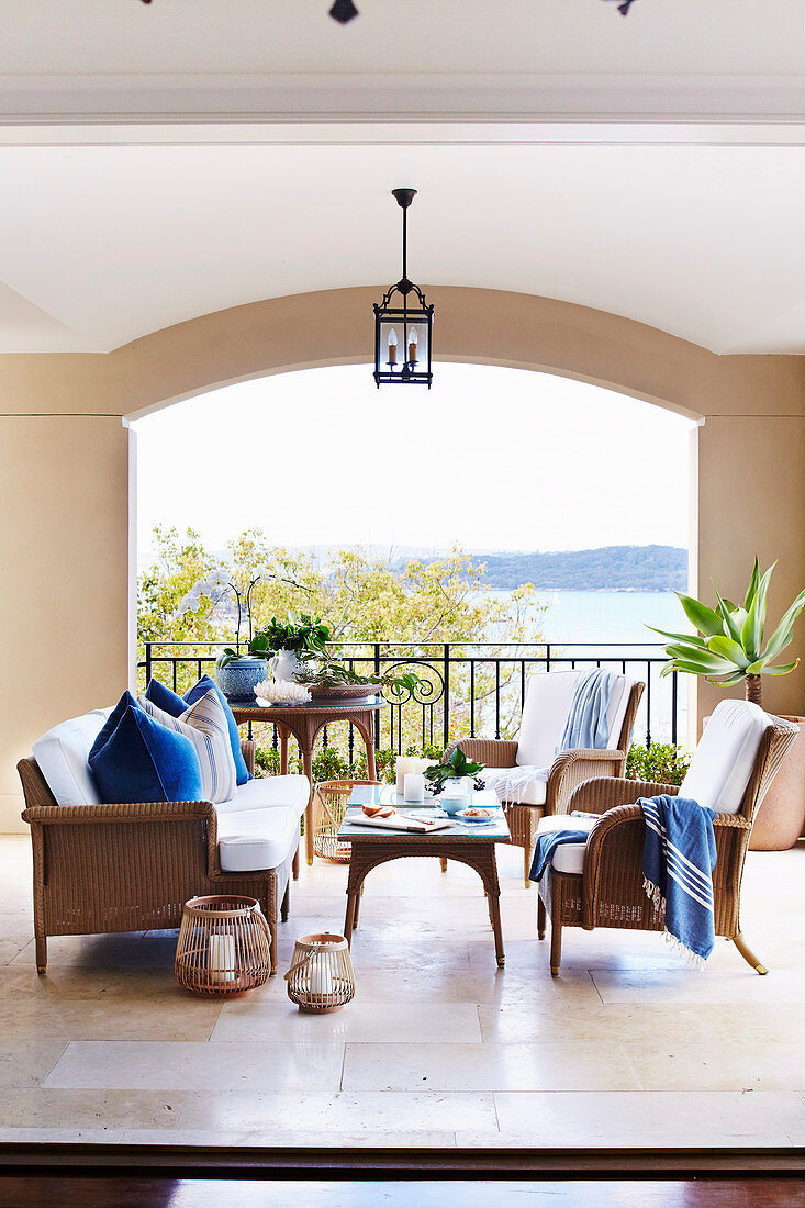 Elegant rattan furniture on a covered veranda with sea views