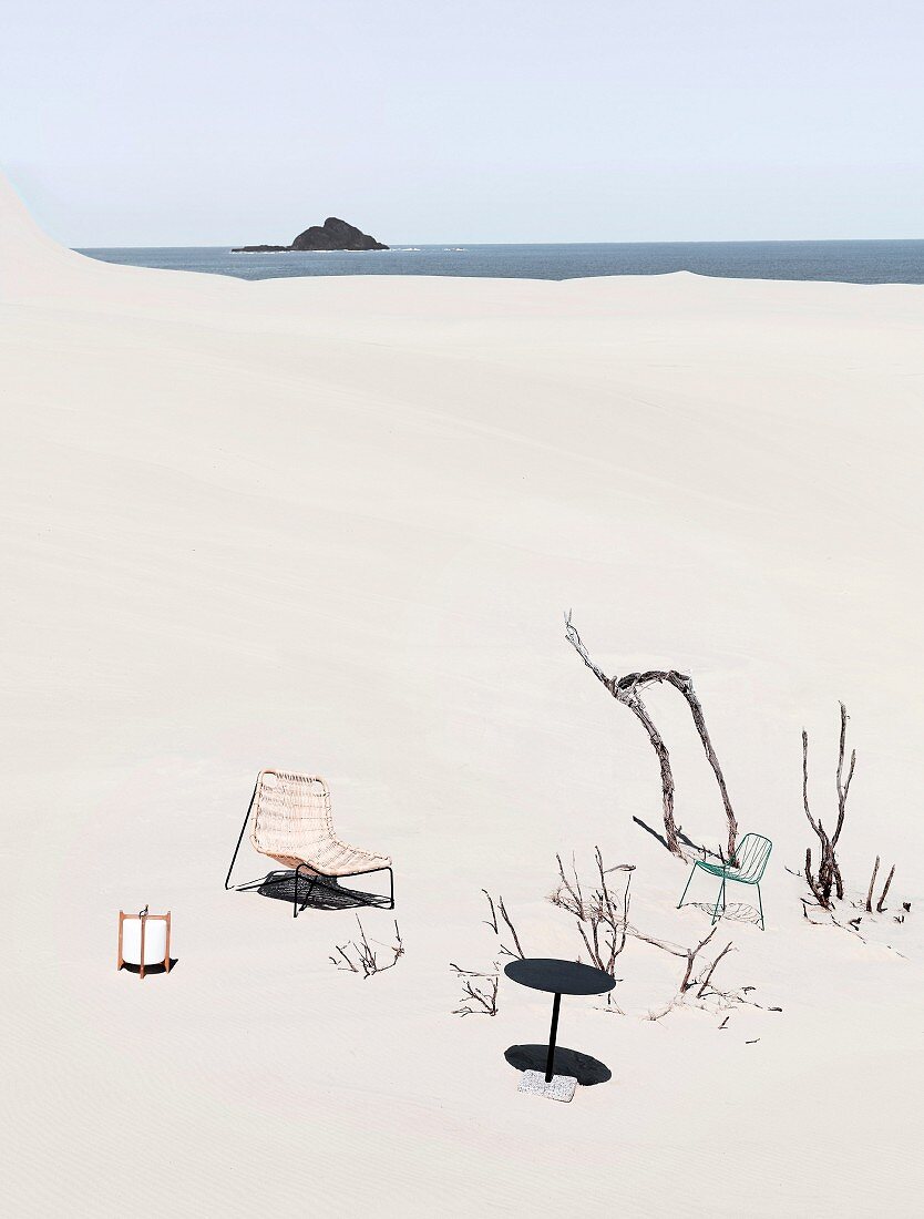 Gartenmöbel auf einsamer Flur im Sand am Meer