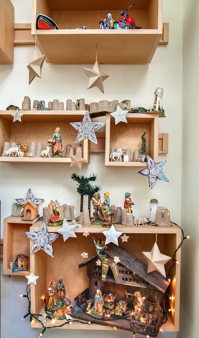 Weihnachtsdeko und Krippe in Holzkästen an der Wand