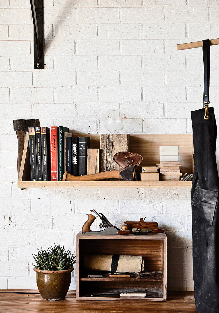 Shelves of tools and books on a brick wall