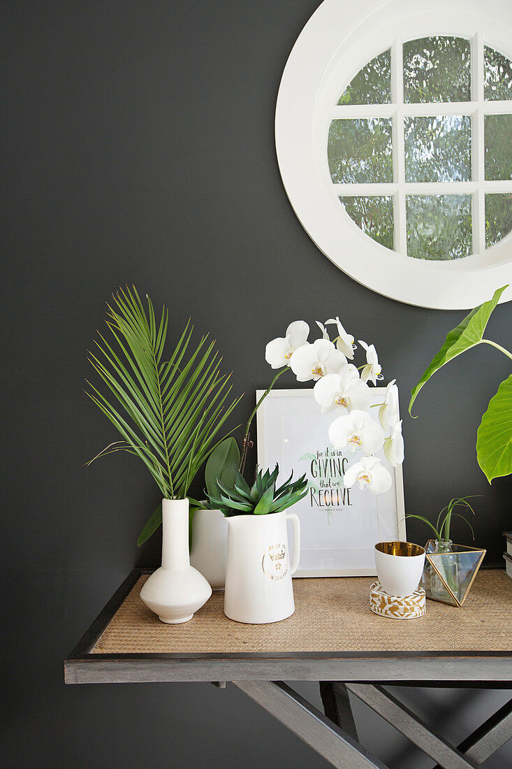 Dekorierter Konsolentisch mit Pflanzen in weißen Vasen