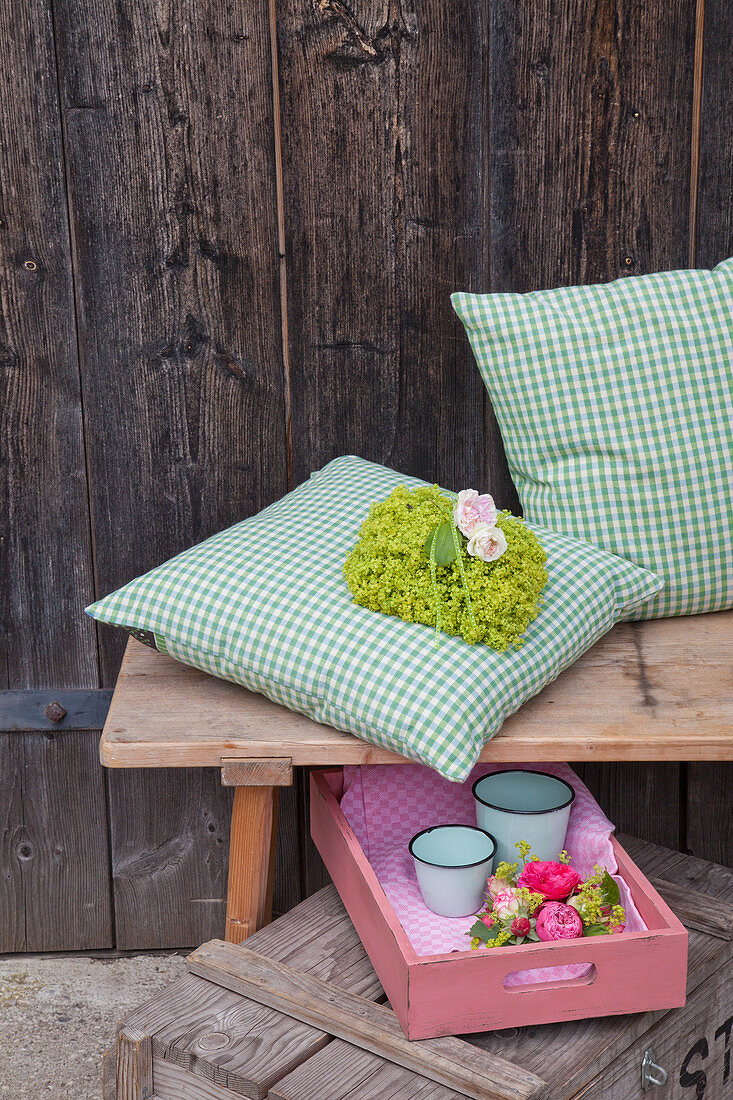 Lady's mantle and roses on cushion with green gingham cover