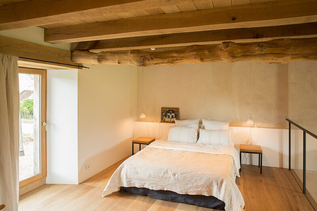 Schlichtes Schlafzimmer mit rustikaler Balkendecke