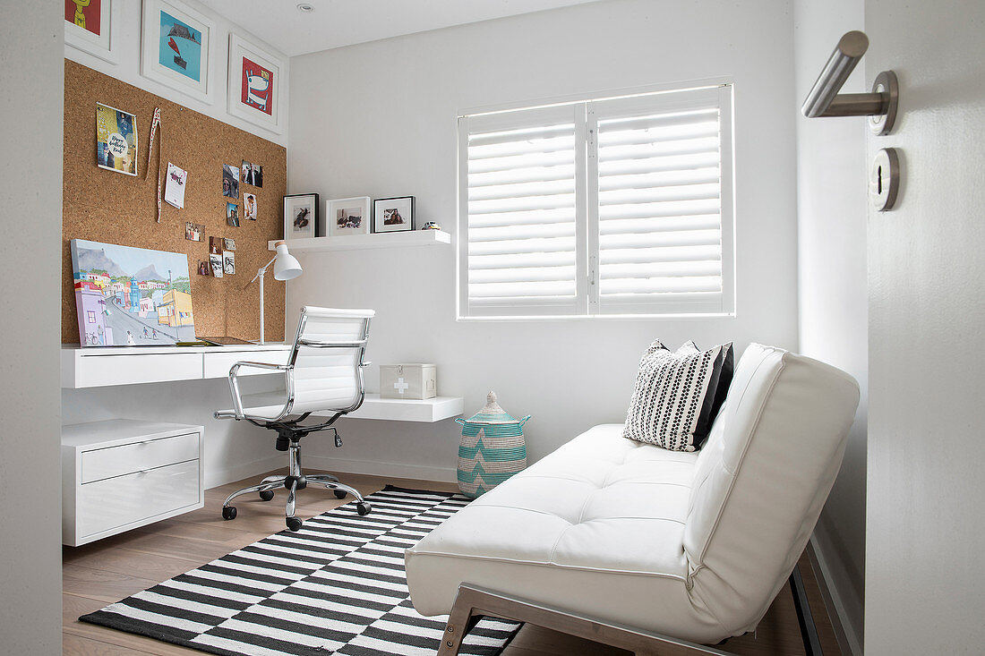 Arbeitszimmer mit weißem Schlafsofa und schwarz-weißem Teppich