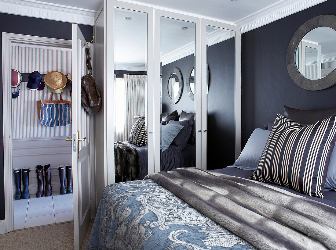 Doppelbett und Kleiderschrank mit Spiegeltüren im Schlafzimmer