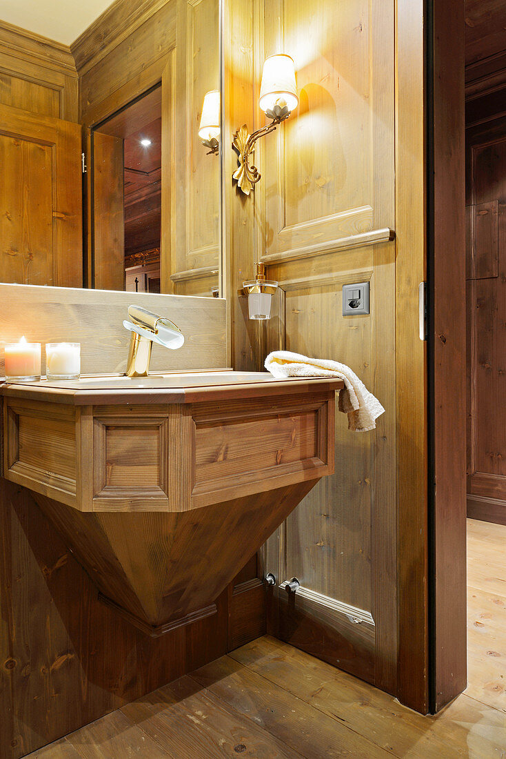 Luxurious bathroom panelled in wood with panelled sink