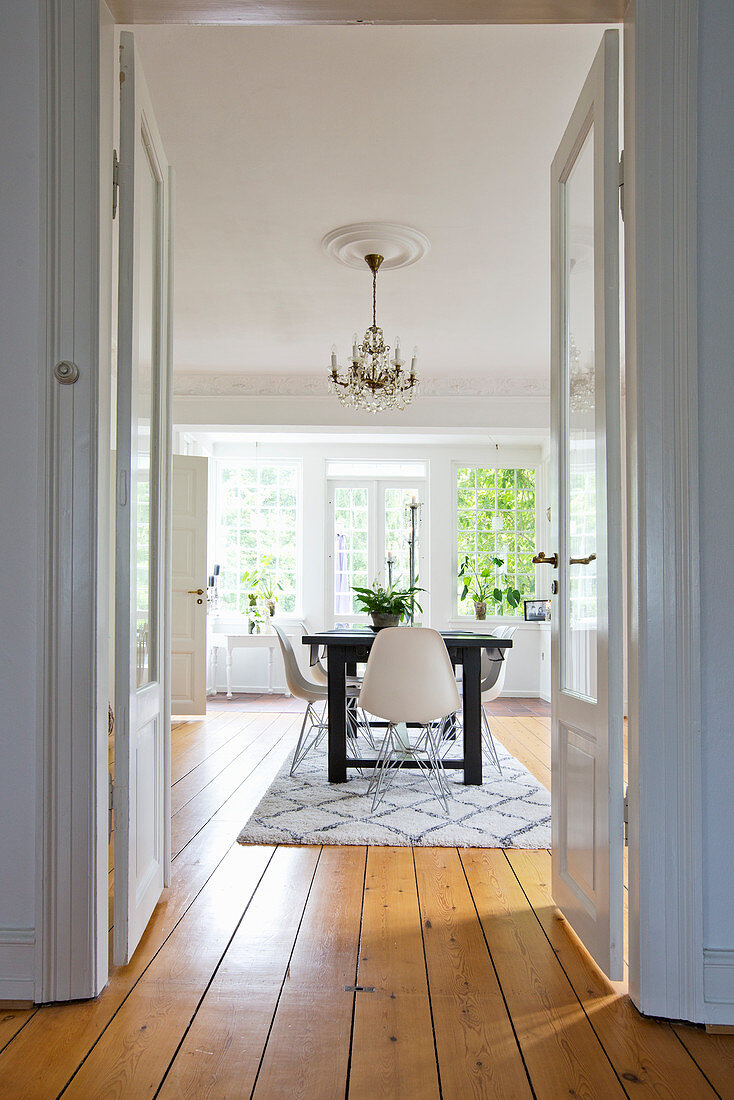 View through open double doors into dining room with wooden floor