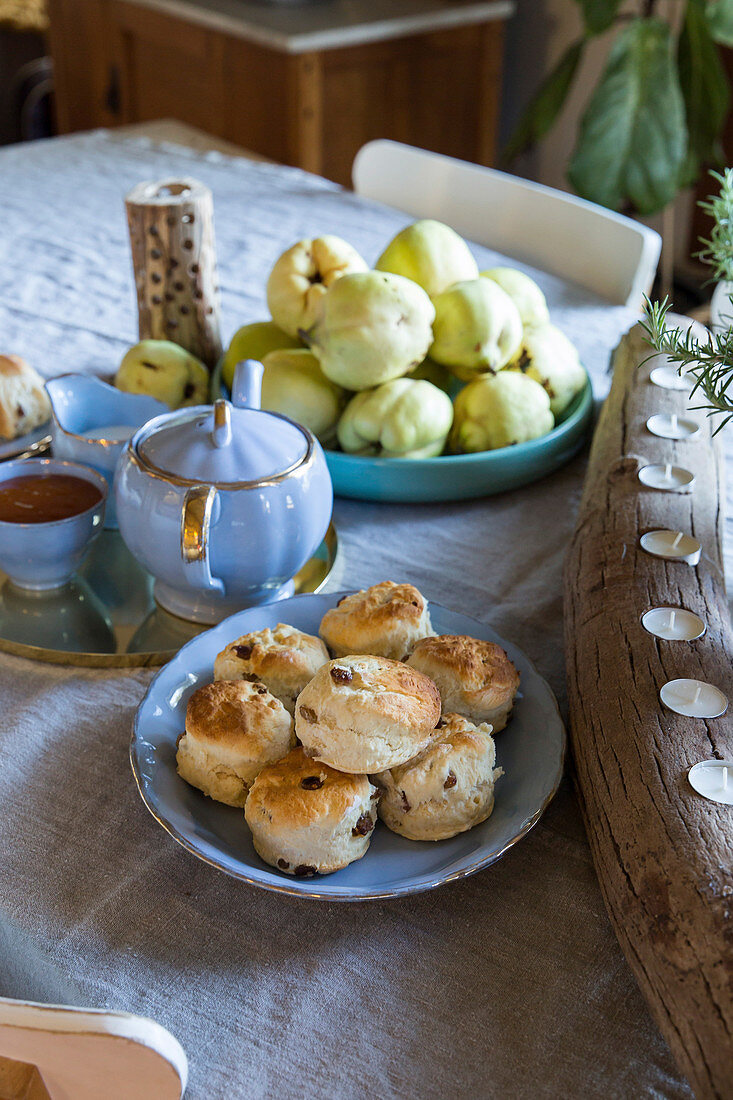 Pastries, crockery and fruit on a country dining table