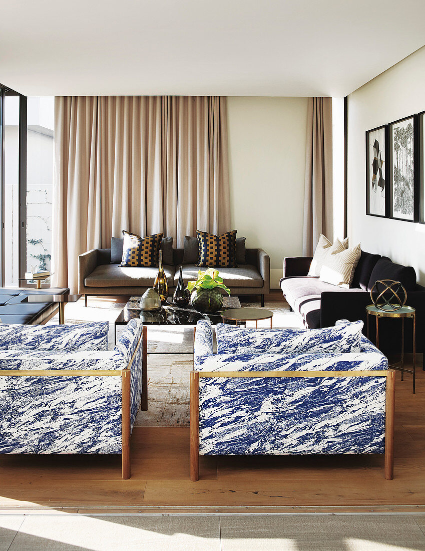 Blau-weiß marmorierte Sessel im modernen sonnigen Wohnzimmer