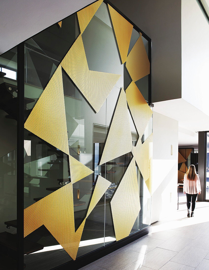 Gold geometric shapes on glass wall of stairwell