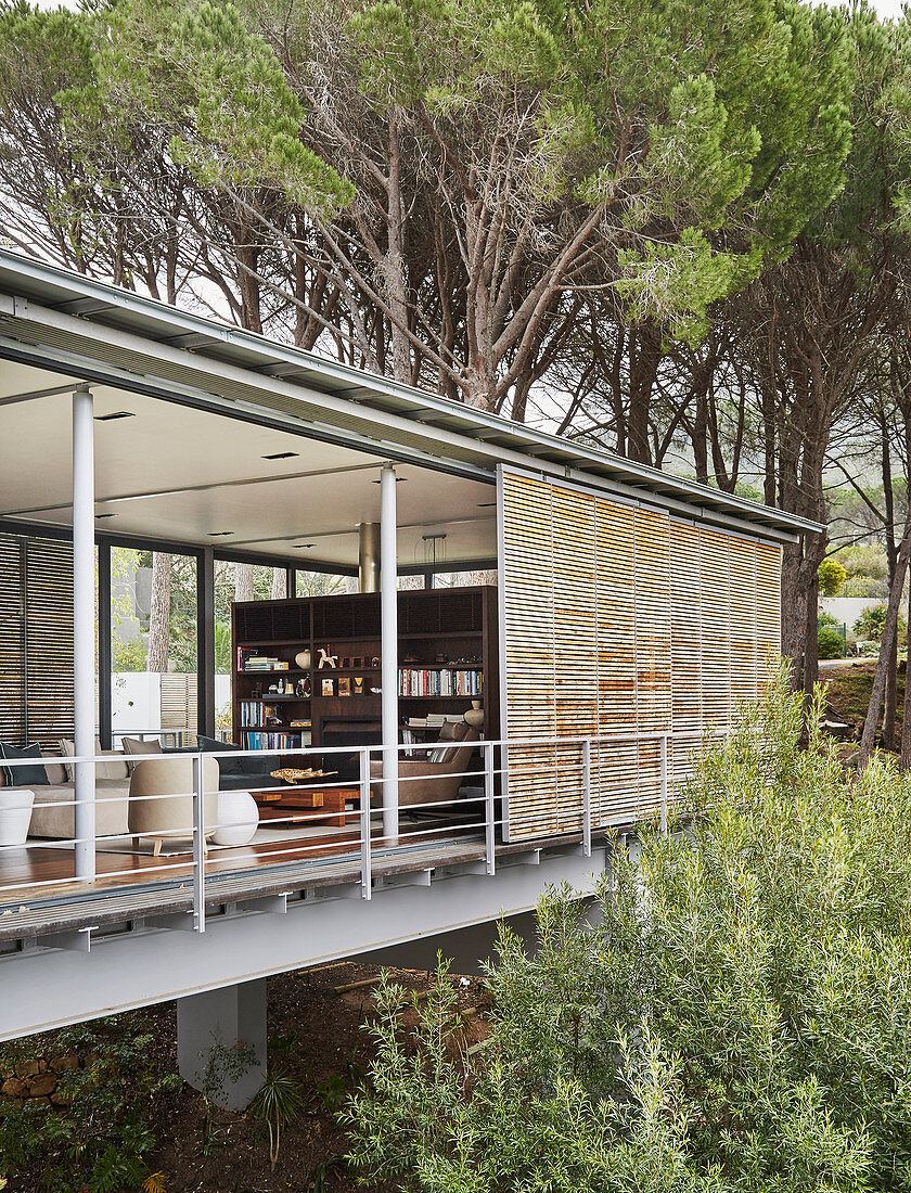 Modern architect-designed house on stilts with open façade in woods