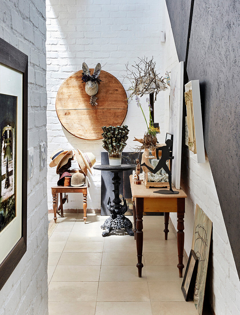 Artworks in hallway on brick wall and on old tables