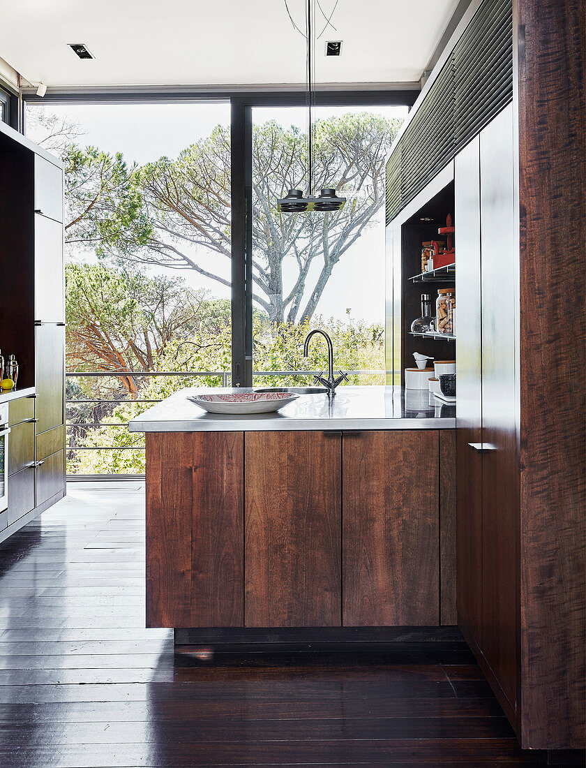 Moderne Küche mit dunklen Holzfronten und Glasfront