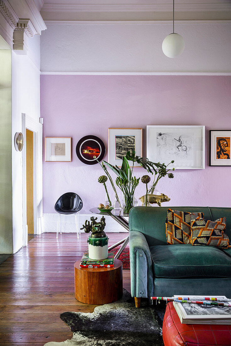 Gallery of pictures on pink wall in artistic living room