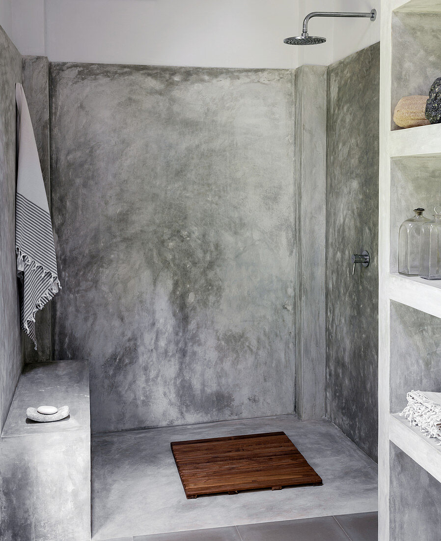 Einfache Dusche mit polierter Zementwand im Gartenhaus