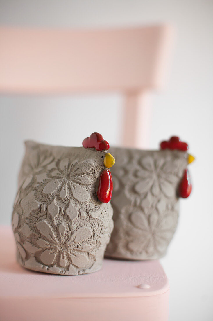 Two ceramic hens with embossed floral patterns