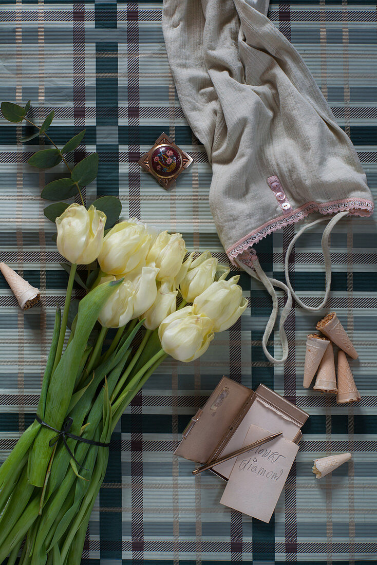 Unterhemd, Notizblock und weiße Tulpen auf karierten Untergrund