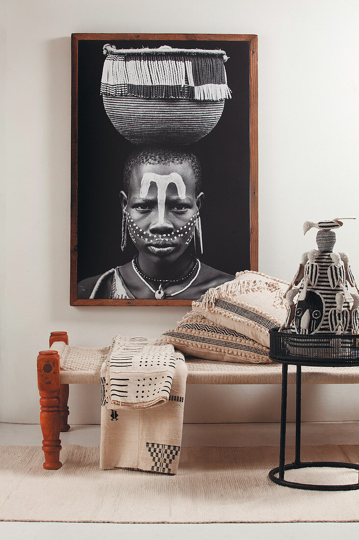 Portrait of African woman with basket above ethnic accessories on couch