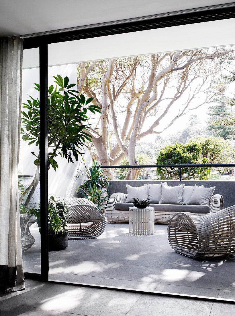 Designer-Korbmöbel und Grünpflanzen auf Balkon