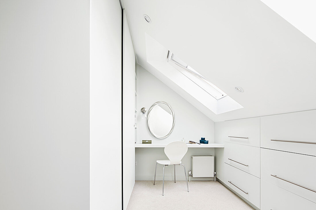 Bright, white attic room with fitted cupboards