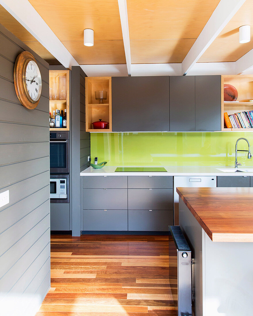 Einbauküche mit grauen Schrankfronten und grünem Spritzschutz