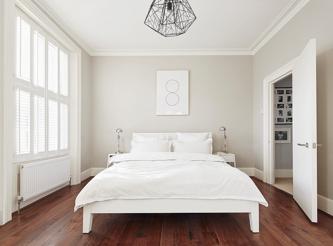 Schlafzimmer ganz in Weiß mit Holzboden
