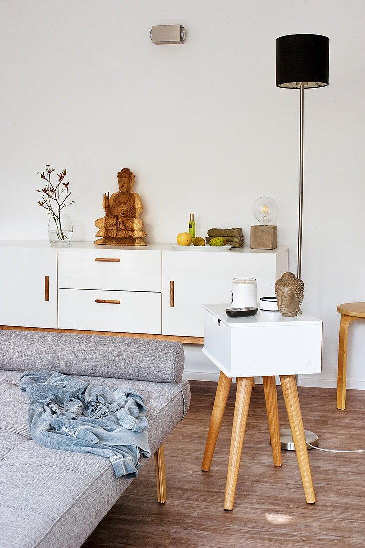 Modern side table with drawer next to grey couch