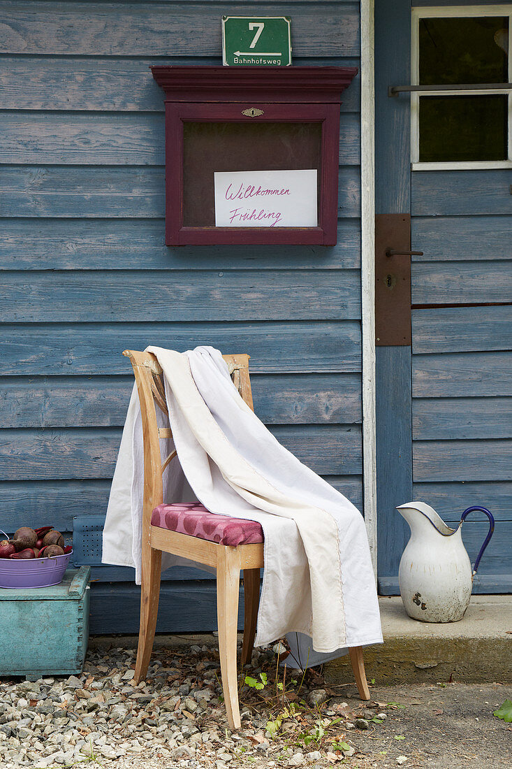 Bed sheet on chair outside wooden house
