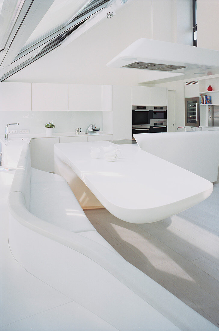 Dining table and curved corner bench in futuristic kitchen-dining room