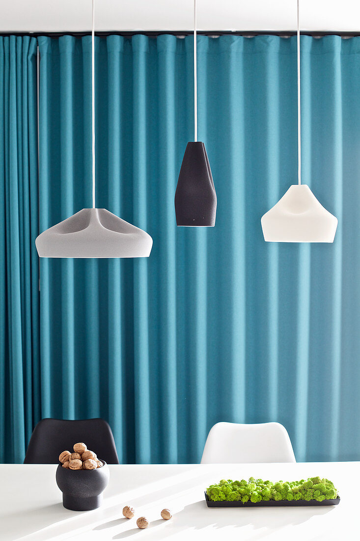 Designer pendant lamps above nuts on white table