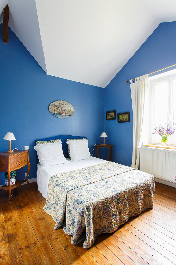 French bedroom with sloping ceiling and blue walls