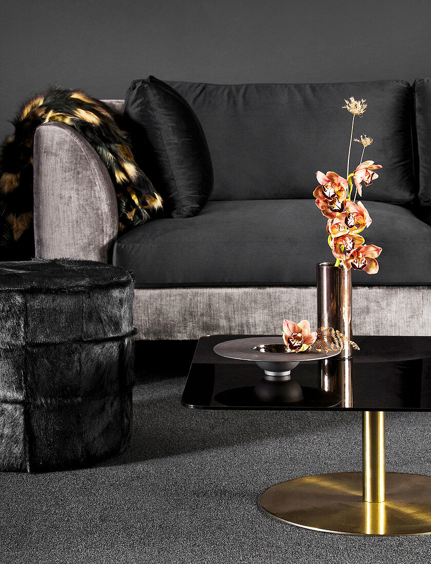 Sofa mit schwarzem Samtbezug, Hocker und Couchtisch mit Orchidee